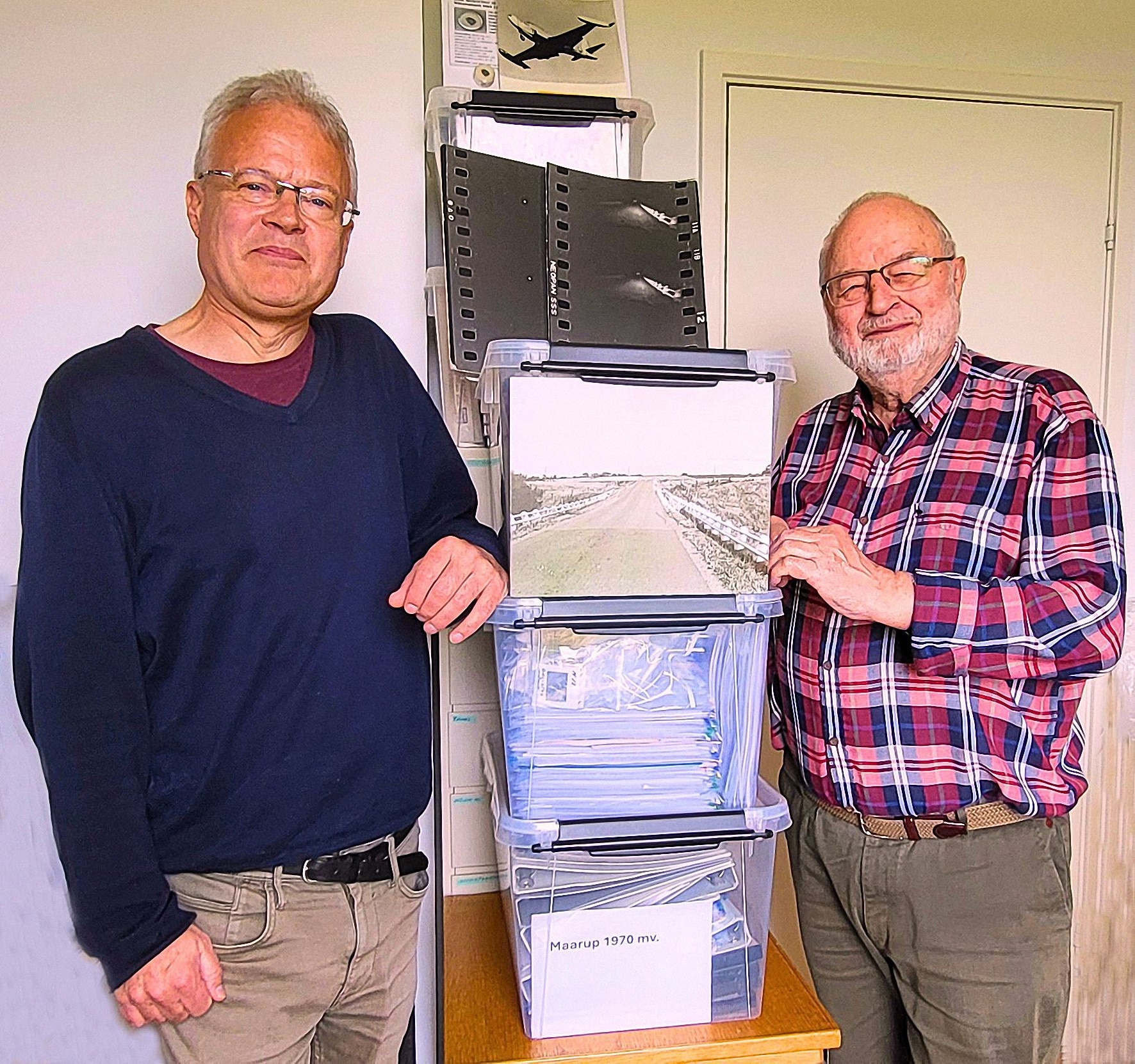 Forfatterne ved kasserne> Her ses forfatterne, Asger Poulsen (tv.) og Ole Henningsen, ved de 5 kasser med materialer, som de gennemgår i bogen.